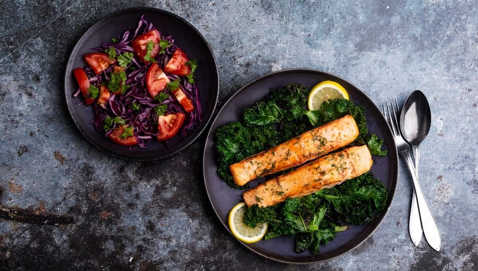 Salmon served with tomato salad on plate