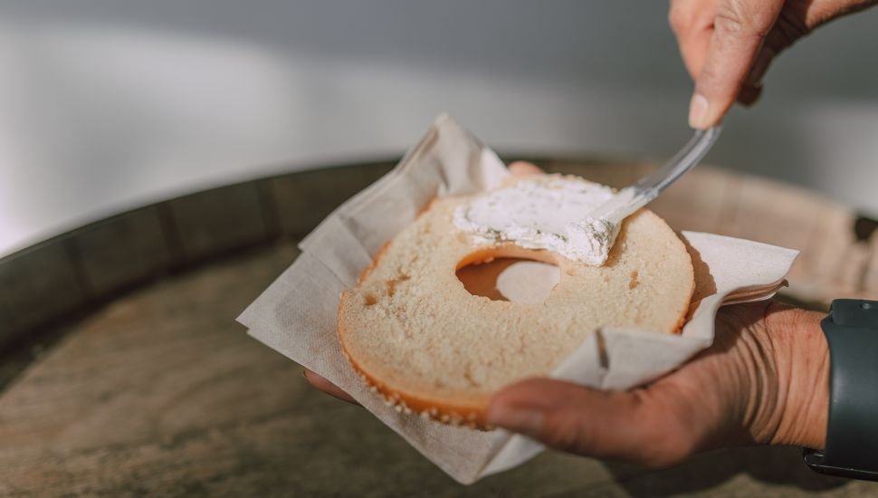 a guy using cream cheese as a spread