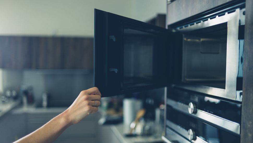 a person opening the microwave door