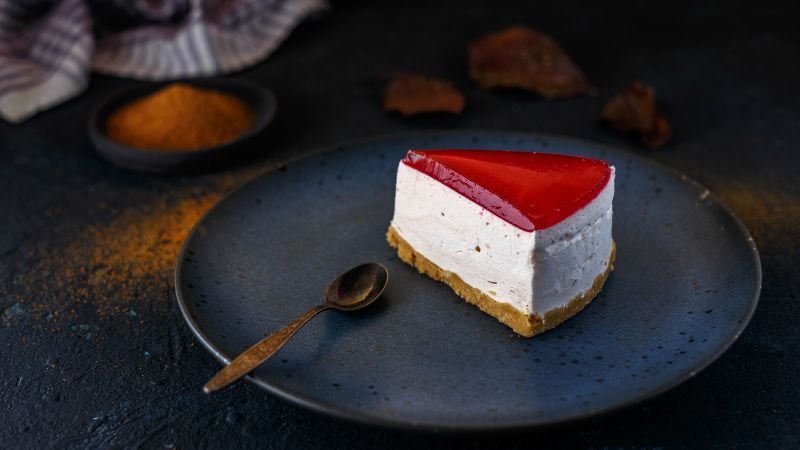 a slice of cheesecake with red toppings
