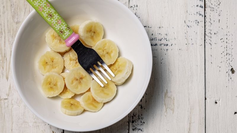 sliced banana in bowl with fork