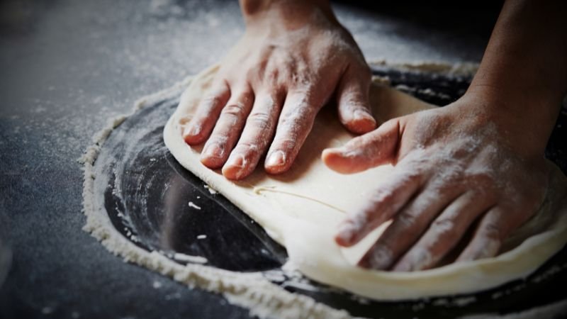 hands of a chef preparing pizza dough