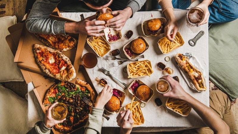 image of burgers, fries and pizza on table