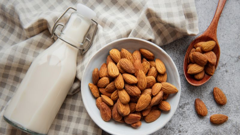 image of milk in bottle and some almonds