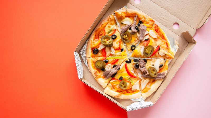 pizza in box with white and red background