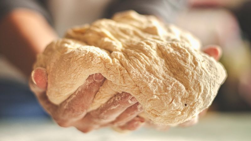 image of a person holding dough by two hands