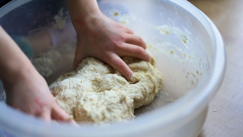 kneading dough in plastic bucket